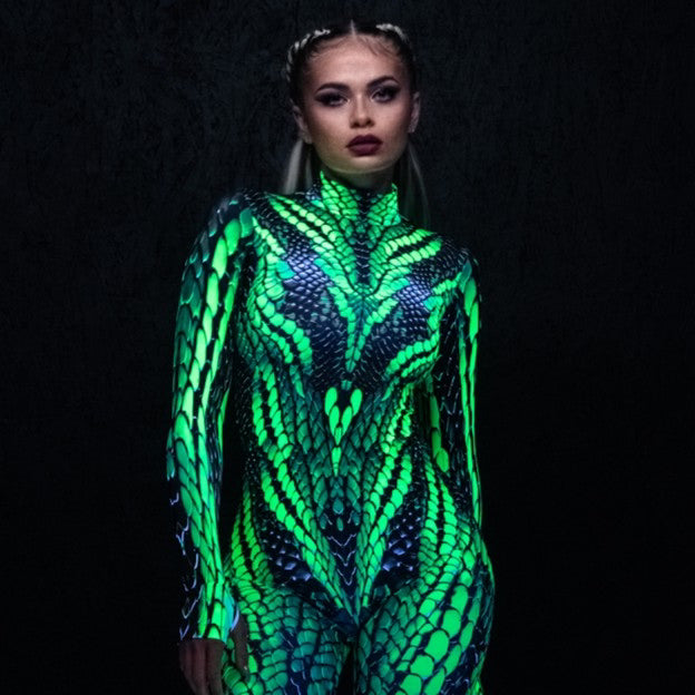 Woman wearing a vibrant green and blue reptile-print bodysuit with black platform boots, styled for Walker & Royce in El Paso.